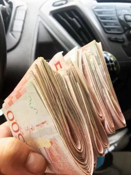 A stack of 500 Swedish kronor banknotes are passed around inside the car Stock Photos