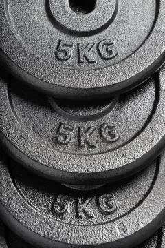  Stack of 5kg barbell / dumbbell weight plates inside a weightlifting gym ... Stock Photos