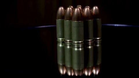 A stack of 9mm bullets with reflection on the glass plate of rotating table. Stock Footage 263063715