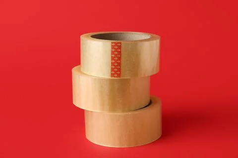 Stack of adhesive tape rolls on red background Fotos de archivo