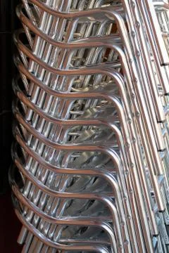 Stack of aluminium chairs in a restaurant. Stock Photos
