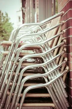 A stack of aluminum chairs from a restaurant Stock Photos