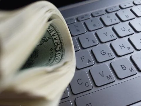Stack of american dollars on laptop keyboard background. A lot of american do Stock Photos