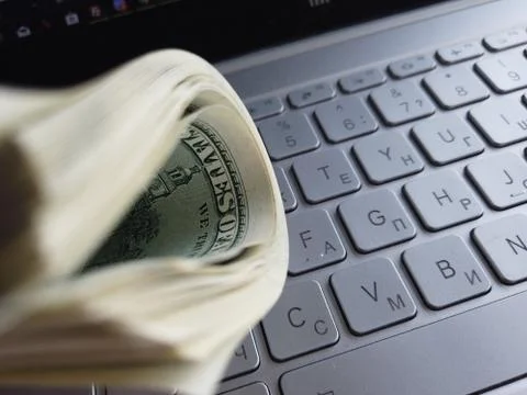 Stack of american dollars on laptop keyboard background. A lot of american do Foto stock