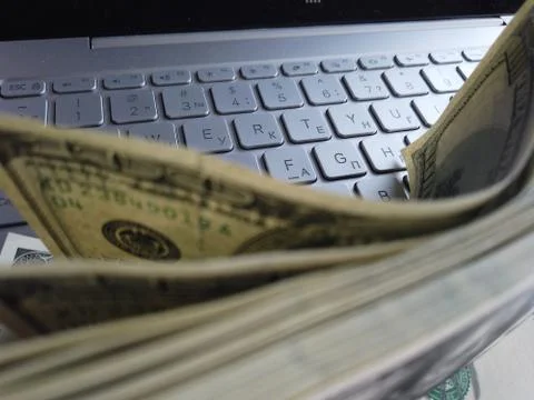 Stack of american dollars on laptop keyboard background. A lot of american do Foto stock