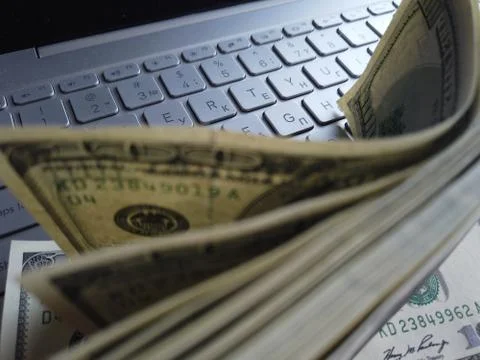 Stack of american dollars on laptop keyboard background. A lot of american do Foto stock