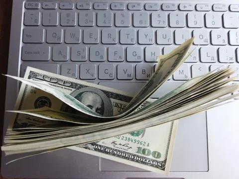 Stack of american dollars on laptop keyboard background. A lot of american do Foto stock