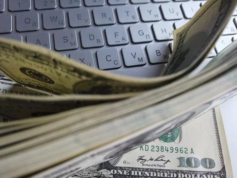 Stack of american dollars on laptop keyboard background. A lot of american do Foto stock