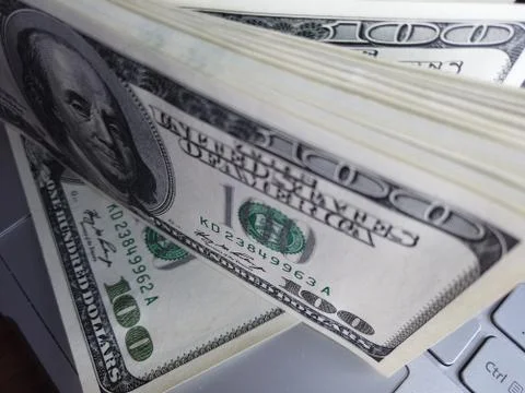 Stack of american dollars on laptop keyboard background. A lot of american do 스톡 사진