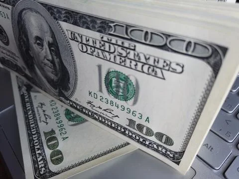 Stack of american dollars on laptop keyboard background. A lot of american do Stock Photos