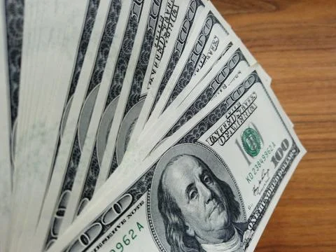 Stack of american dollars on wooden background. A lot of American dollars. Stock Photos
