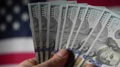 Stack of american hundred dollar bills in hand the background of american flag Stock Footage 300509792