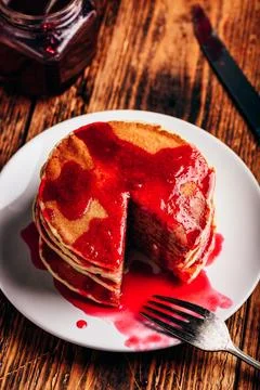 Stack of american pancakes with red berry jam Stock Photos