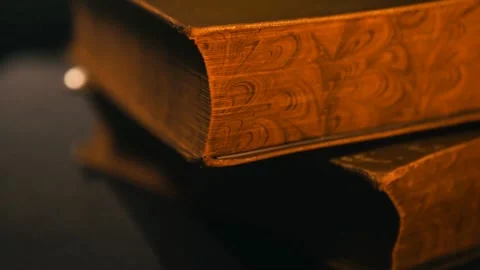 Stack of Antique Books on Table in Low Light Close-Up Stock Footage 314303641