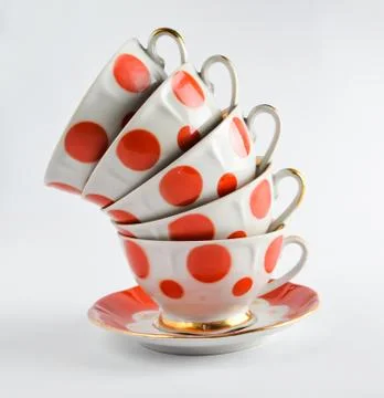 A stack of antique ceramic cups on a saucer on a white background.. A stack o Stock Photos