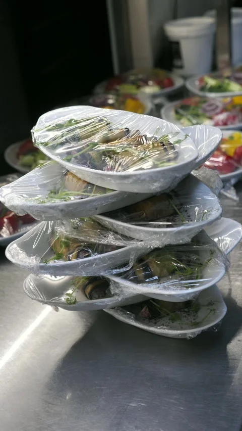 Stack of appetizer plates wrapped in plastic film in a restaurant kitchen. Stock Footage 342150071