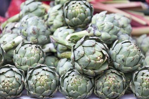 Stack of artichokes on a market stall Stock Photos