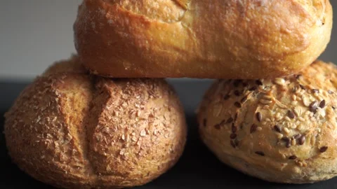 Stack of assorted bread rolls in soft focus studio loop video Video stock 318844493