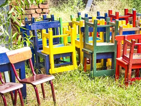 Stack of assorted colored wooden chairs in random disarray, full frame furn.. Stock Photos