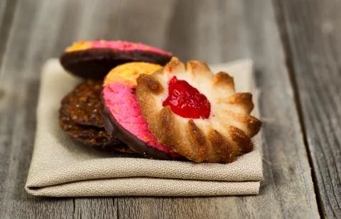 Stack of assorted cookies in cloth napkin on wood Stock Photos