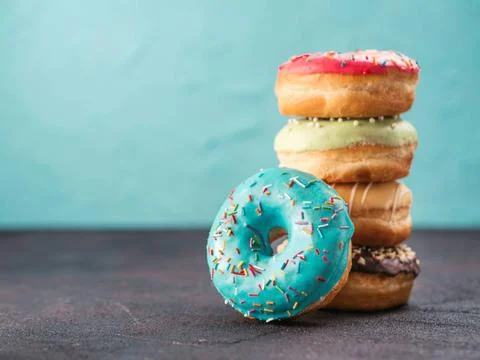 Stack of assorted donuts, copy space Stack of assorted donuts on black and... Stock Photos