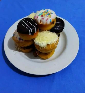 Stack of Assorted Mini Donuts on White Plate Stock Photos