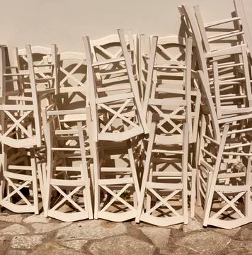 Stack of assorted wooden chairs in random disarray, full frame furniture back Stock Photos