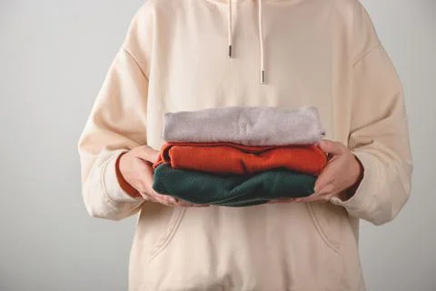 Stack of autumn basic women's turtlenecks in trendy colors in female hands Stock Photos