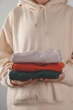 Stack of autumn basic women's turtlenecks in trendy colors in female hands Stock Photos