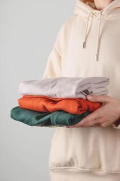 Stack of autumn basic women's turtlenecks in trendy colors in female hands Stock Photos