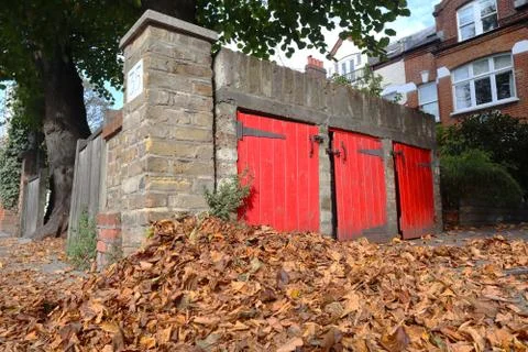 Stack of autumn leaves in front of a victorian house in Putney Stock Photos