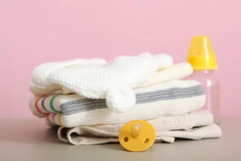 A stack of baby clothes on a light background. Stock Photos