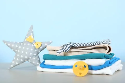 A stack of baby clothes on a light background. Stock Photos
