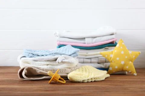 A stack of baby clothes on a light background. Stock Photos