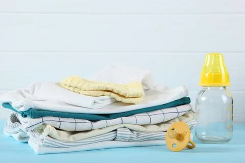 A stack of baby clothes on a light background. Stock Photos