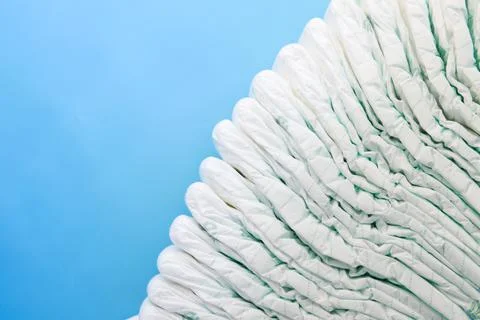 Stack of baby diaper on blue background with copy space Stock Photos