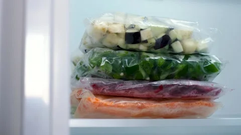 Stack of bags with chopped and frozen vegetables in refrigerator close-up. Stock Footage 290298894