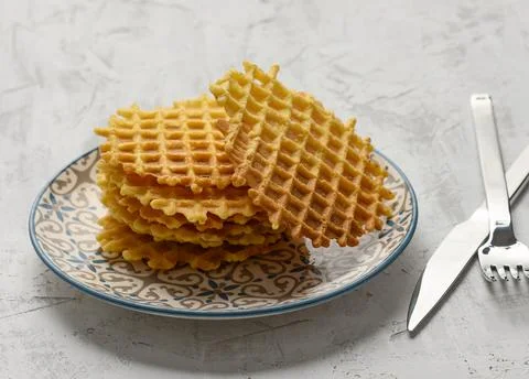 Stack of baked Belgian waffles on a round plate on a white table Stockfoto's