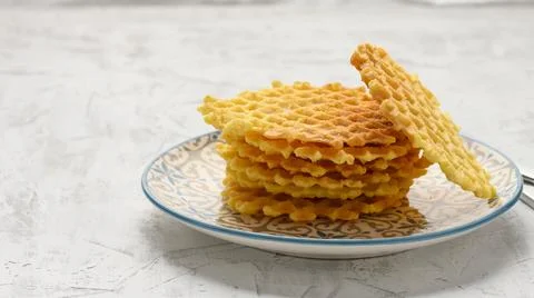 Stack of baked Belgian waffles on a round plate on a white table, delicious b Stock-Fotos
