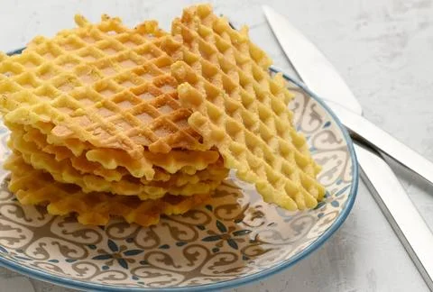 Stack of baked Belgian waffles on a round plate on a white table, deliciou... Stock Photos