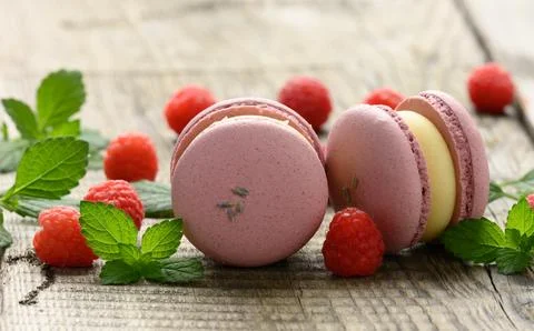 Stack of baked raspberry macarons and berries on a gray table Stock Photos