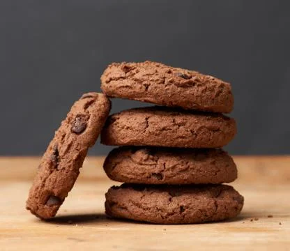 Stack of baked round chocolate chip cookies on a brown wooden table Foto stock
