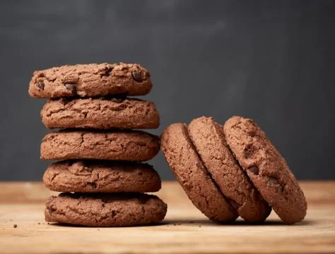 Stack of baked round chocolate chip cookies on a brown wooden table Stock-Fotos