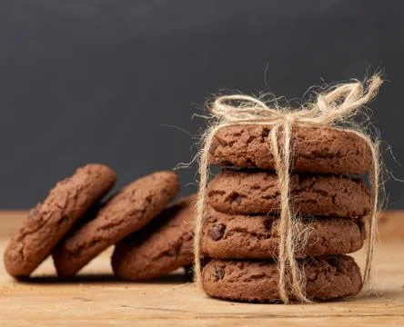 Stack of baked round chocolate chip cookies on a brown wooden table Foto stock