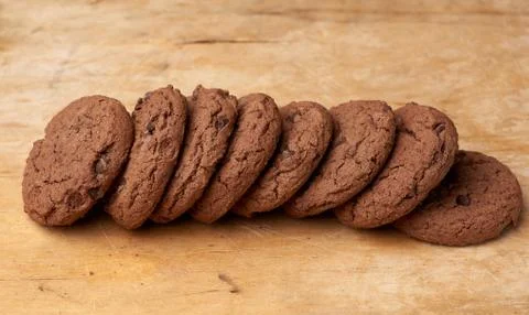 Stack of baked round chocolate chip cookies on a brown wooden table Foto stock