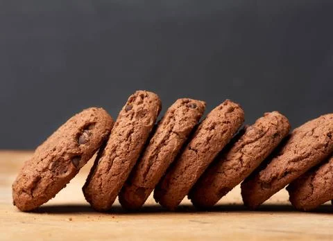 Stack of baked round chocolate chip cookies on a brown wooden table stack ... Stock-Fotos