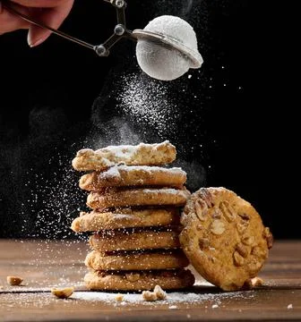 A stack of baked round cookies sprinkled with powdered sugar on a wooden tabl Stock-Fotos