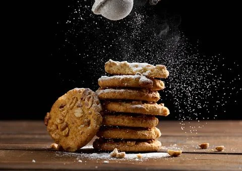 Stack of baked round cookies sprinkled with powdered sugar on a wooden table, Stock Photos