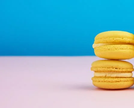 Stack of baked round yellow lemon macarons on a blue-pink background Stockfoto's