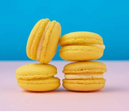 Stack of baked round yellow lemon macarons on a blue-pink background stack... Stock Photos